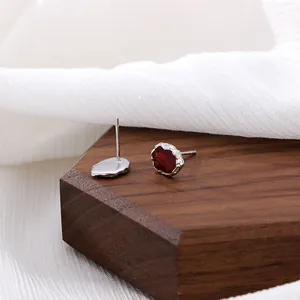 Vintage silver metal studs with deep red gemstone and irregular hammered texture finish