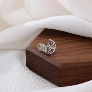 Ear cuff vintage in argento traforato stile etnico su legno scuro e tessuto bianco
