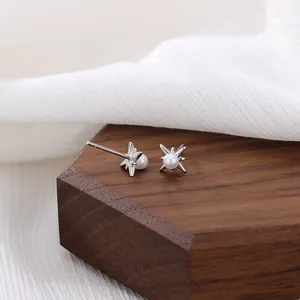 S925 Silber Nordstern Ohrstecker mit natürlichen Süßwasserperlen auf dunklem Holz
