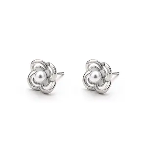 Elegant silver hollow camellia stud earrings with white pearl center on white background