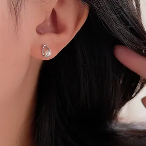 Elegant hollow teardrop pearl earrings in S925 sterling silver worn on ear