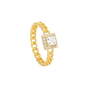 Anello dorato a maglia cubana con pietra di zircone quadrata su sfondo bianco puro