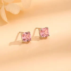 Pink cushion-cut zircon stud earrings in silver four-claw setting on beige background