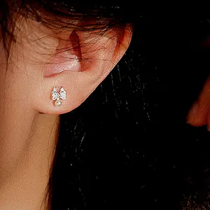 Elegant silver bow stud earrings with sparkling pavé zircon and hanging white pearl drop
