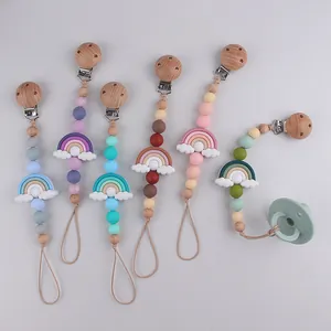 Detail view of colorful silicone rainbow pacifier clips with wood beads and metal fasteners