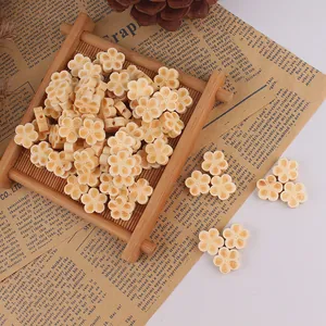 Macro shot of cream floral wooden beads for DIY jewelry making on a bamboo mat background
