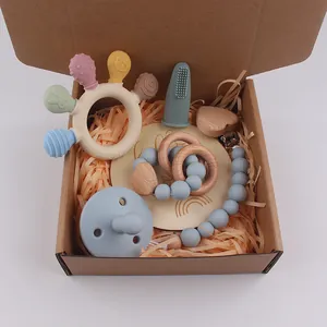 Silicone baby teether and pacifier set with wooden clip in a kraft gift box
