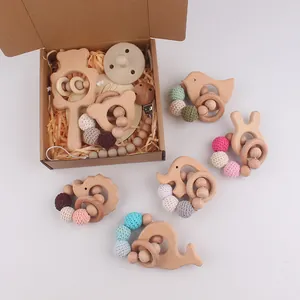 Detailed close-up of natural beech wood baby rattle set with crochet beads in gift box