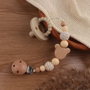 Beech wood bear pacifier clip set with silicone beads on a wooden surface