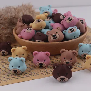 Detail of colorful cartoon bear silicone beads for DIY handmade jewelry in a wooden bowl