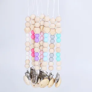 Collection of wooden and silicone pacifier clips in seven soft pastel color variations