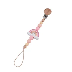 Handmade silicone and wood pacifier clip with rainbow charm for baby soothing