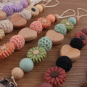 Detailed view of beech wood pacifier clips with crochet beads and sunflower silicone accents