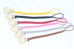 Détail de six attaches-tétines tressées avec boucles en bois rondes de couleurs variées