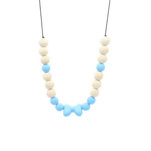Détail du collier de dentition pour bébé avec perles en silicone bleu ciel et bois