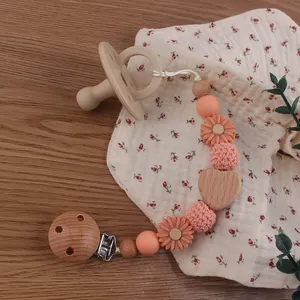 Detail of beechwood baby pacifier clip with silicone beads and sunflower charm