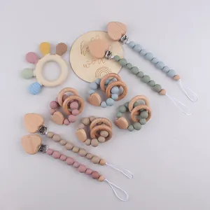 Detail of silicone pacifier clip and wooden teething rings in Morandi color palette