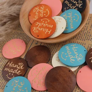 Close-up of assorted colorful handmade wooden pendants with smiley and heart engravings