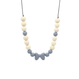 Détail du collier de dentition pour bébé avec perles en bois et pendentif nœud bleu