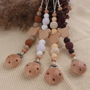 Detailed set of four beech wood pacifier clips with silicone beads and crochet textures