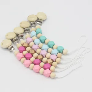 Cinq attaches-tétines assorties en bois et silicone de diverses couleurs sur fond blanc