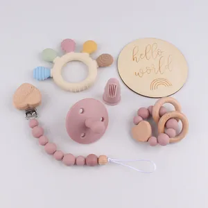 Macro detail of baby teething set with silicone pacifier chain and wooden teething ring