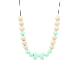 Détail du nœud en silicone et perles en bois sur collier de dentition bébé