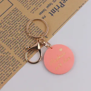 Detail view of pink wooden keychain with golden Handmade with love engraving and heart charm