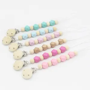 Détail d'un lot de six attaches-tétines en bois et silicone aux couleurs pastel variées