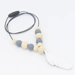 Détail du collier de dentition en silicone avec plume et perles en bois et fermoir de sécurité
