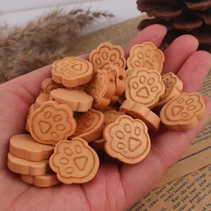 Macro shot of paw-shaped wooden beads held by hand for DIY jewelry making material