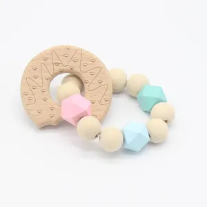 Detail of baby beech wood teething ring and pastel silicone beads for infant motor development