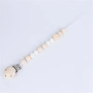 Detailed macro view of wooden pacifier clip with natural beads and metal fastener