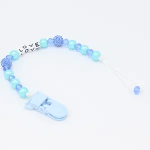 Detail of blue baby pacifier clip with LOVE letter beads and crystal-style pearls