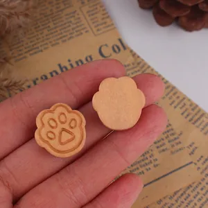 Detailed close-up of handmade wooden cat paw beads for DIY jewelry and crafts