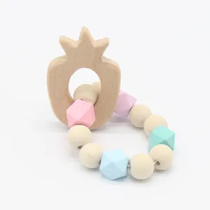 Close-up of pineapple wooden teether and macaron colored silicone bead bracelet for babies