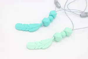 Detail of food grade silicone feather teething necklace with soft mint beads and safety clasp