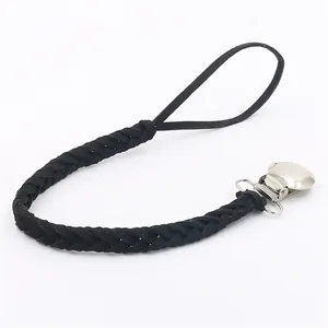 Detail of black braided leather pacifier clip with silver metal clamp and ring