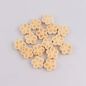 Macro view of flower-shaped wooden DIY beads with laser-engraved texture and natural finish