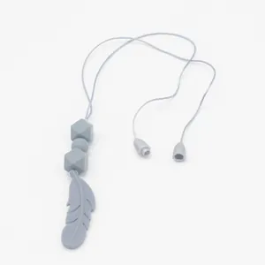 Macro detail of a soft grey silicone feather teething necklace with safety breakaway clasp