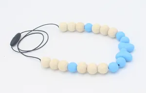 Détail du collier de dentition pour bébé avec nœud en silicone bleu et perles en bois