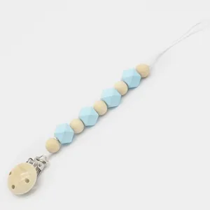 Détail d'attache-tétine en bois avec perles en silicone bleu clair et cordon blanc