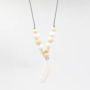 Collier de dentition bébé en silicone avec perles et pendentif plume blanche détaillé
