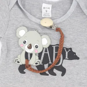 Anneau de dentition koala en silicone avec attache tressée sur un pyjama bébé