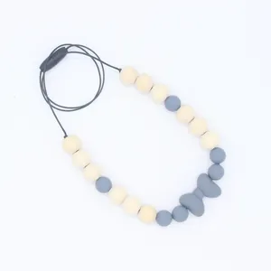Détail du collier de dentition pour bébé avec nœud en silicone, perles en bois et fermoir