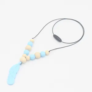 Détail de l'anneau de dentition plume bleu clair avec perles en bois et silicone