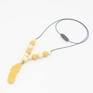 Détail du collier de dentition en silicone jaune gingembre avec perles en bois