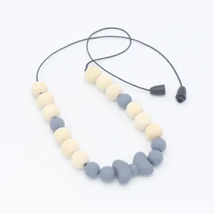 Détail du pendentif nœud en silicone et perles en bois du collier de dentition