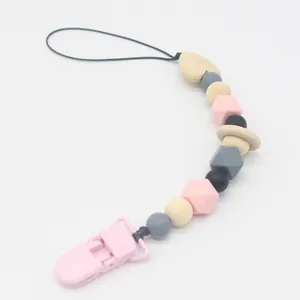 Detail of pink silicone beads and heart-shaped wooden beads on a baby pacifier clip