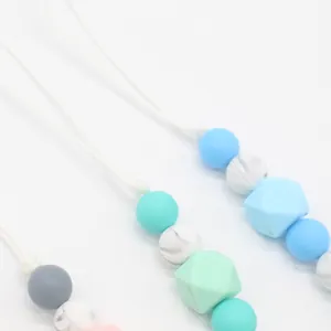 Detail of colorful silicone beads on baby pacifier clip with various geometric shapes